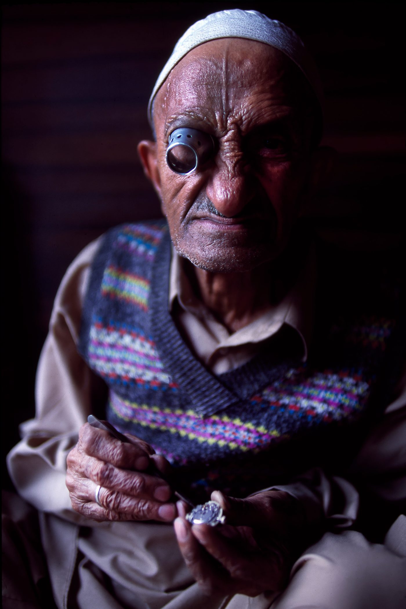 Abdul, a watchmaker in Kashmir, a loupe held in his eye, examining a watch